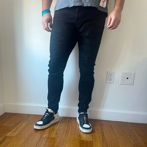 DSQUARED men’s black slim jeans with ripped accents.